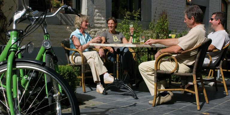 Fietsers pauzeren op een terras van een fietscafé tijdens de fietstocht