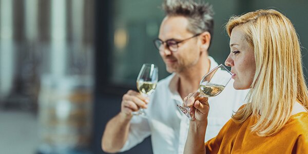 Man en vrouw proeven de witte wijn van wijndomein Gloire de Duras in Sint-Truiden